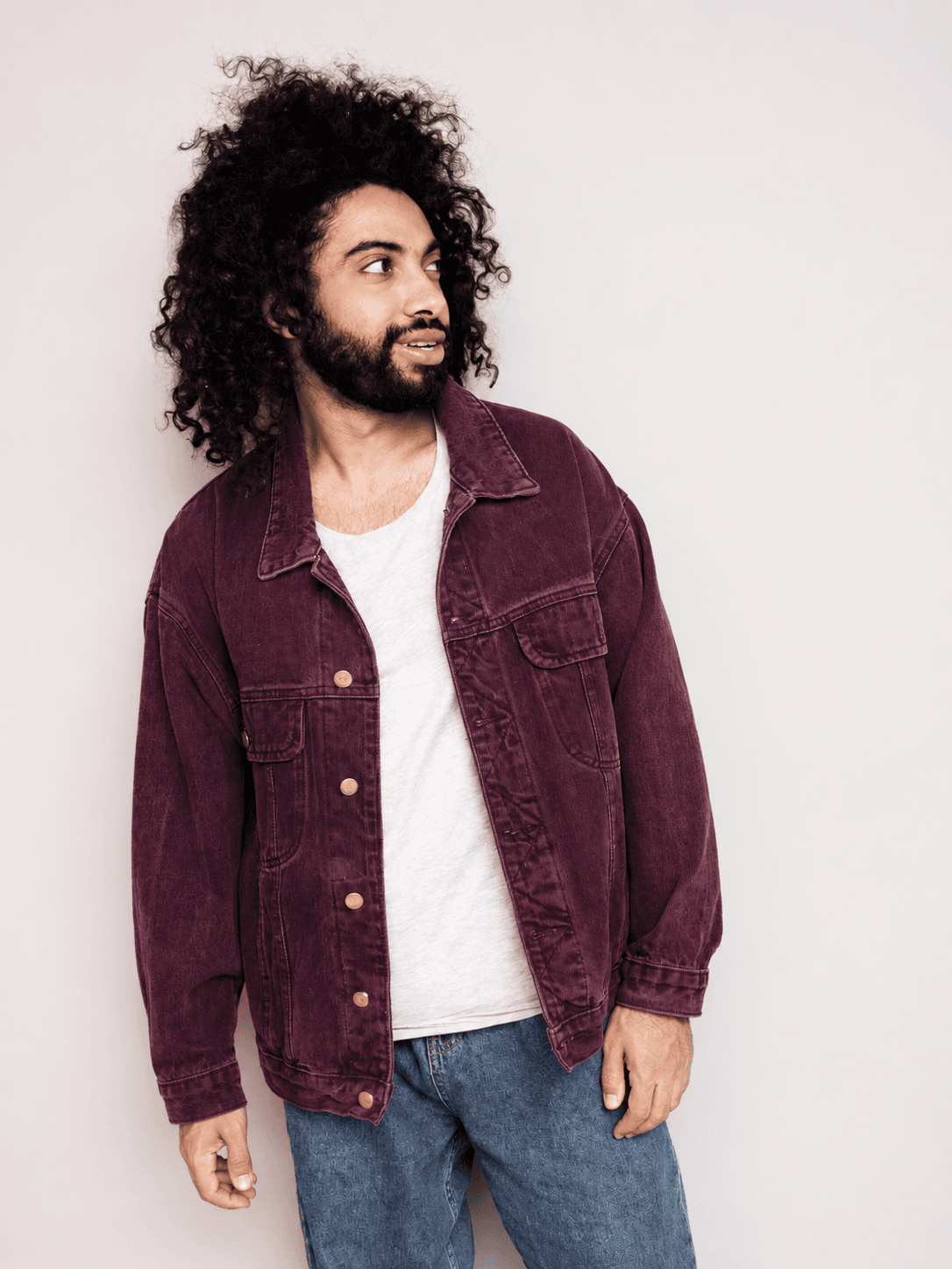 Model wearing a maroon corduroy jacket over a white t-shirt